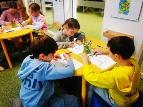 10 dzieci rysują podczas lekcji bibliotecznej