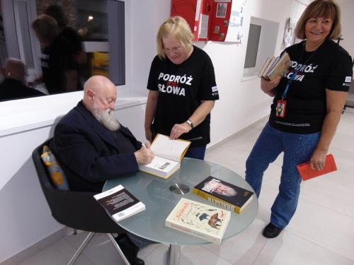 11 Profesor Jerzy Bralczyk podpisuje bibliotekarkom książki