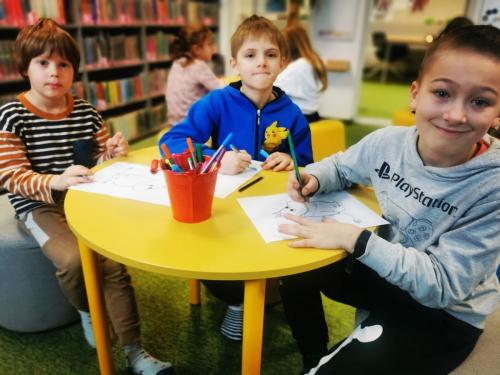 12 dzieci rysują podczas lekcji bibliotecznej