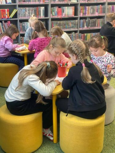 13 dzieci rysują podczas lekcji bibliotecznej