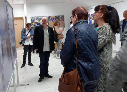 4 Autor i uczestnicy wernisażu oglądają fotografie