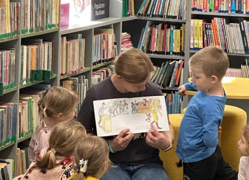 7 ciekawski George bibliotekarka Agnieszka pokazuje dzieciom bajkę
