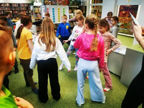 9 dzieci tańczą podczas lekcji bibliotecznej